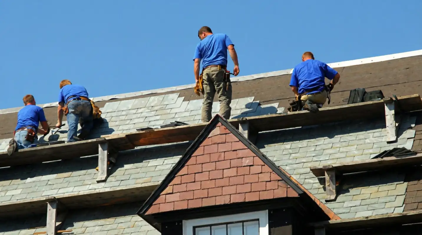 Roof replacement in progress with a team of professional contractors installing new shingles on a residential home in Minneapolis, MN