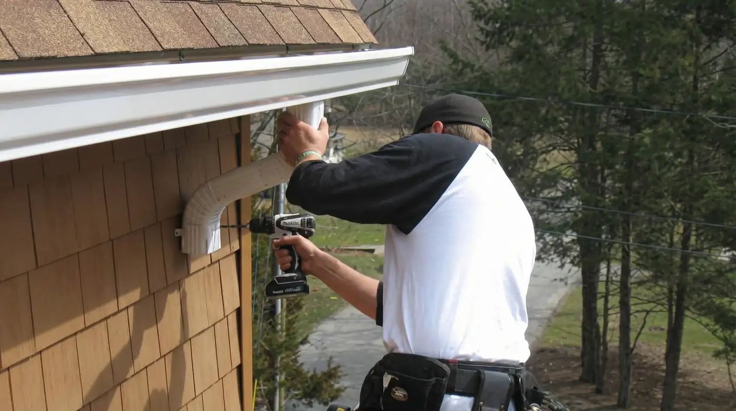 Professional contractor installing tan vinyl siding panels on a residential home exterior in Minneapolis, MN